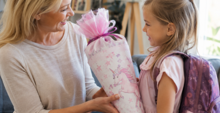 Mutter übergibt Tochter ein Geschenk zur Einschulung